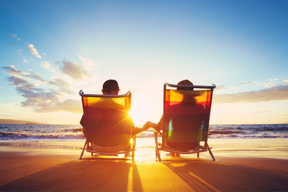 Couple sitting on a beach enjoying retirement